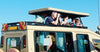 People on an open-top vehicle with a clear blue sky