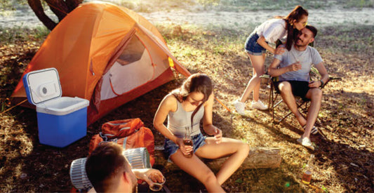 Family camping by a lake with an orange tent and cooler box on group joining safari game drives in Kenya