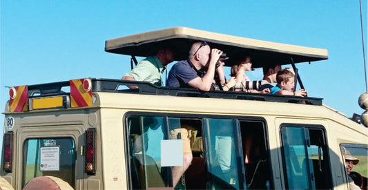 People on an open-top vehicle with a clear blue sky