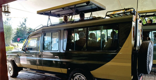 People inside a green 4x4 safari jeep with an open roof, watching on a sunny day on jeep safari vehicle for hire kenya