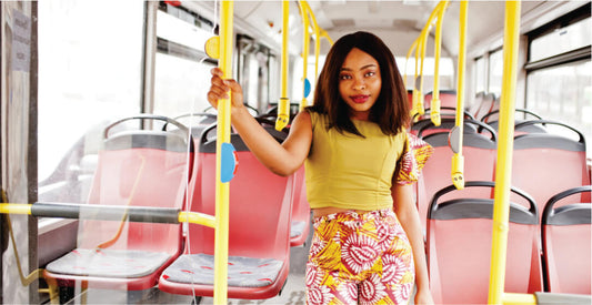 Woman standing on a bus holding onto a yellow handrail